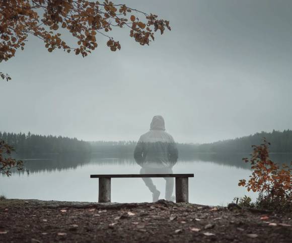 Transparent silhouette overlooking serene water