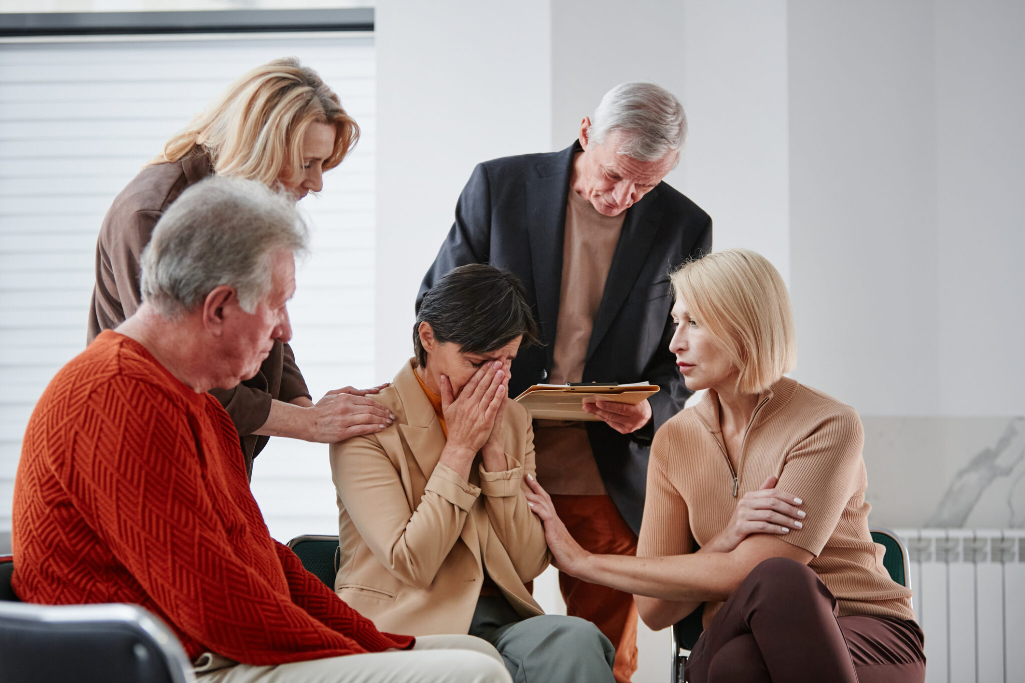 Group comforting a sad woman