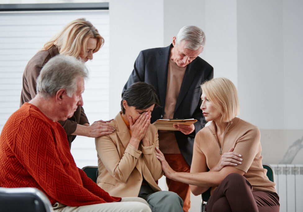 Group comforting a sad woman